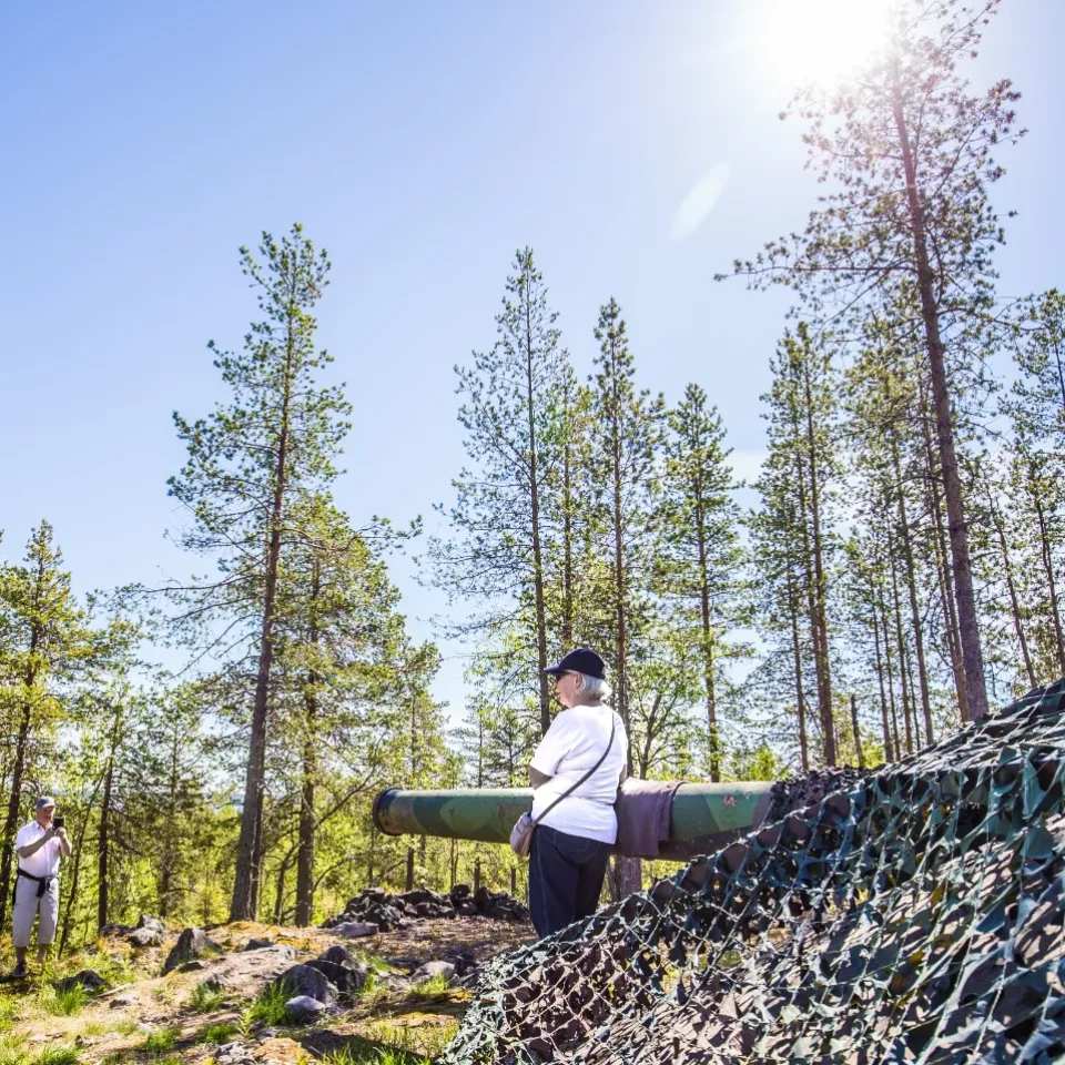 Två människor framför en av Siknäsfortets kanoner.