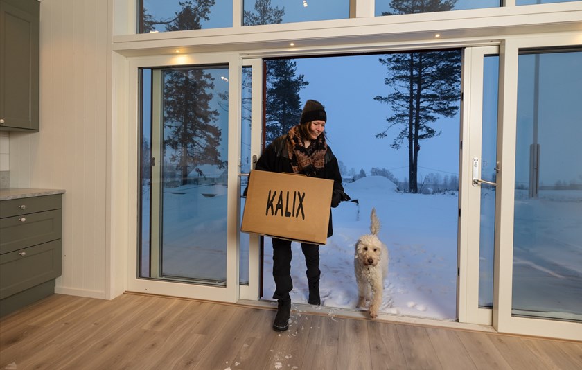 Kicki och hennes hund bör in en flyttlåda i hennes nybyggda hus.