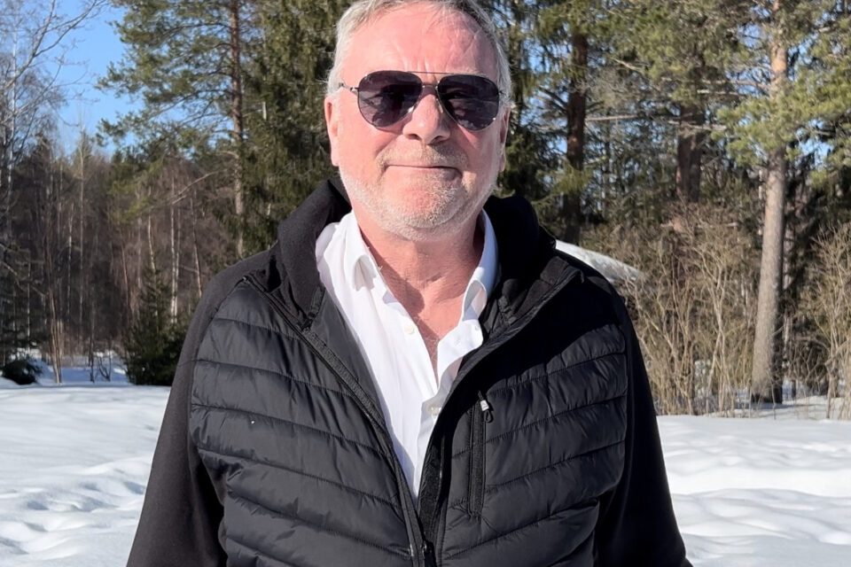 Eddy Stam. A man standing outside, with snow and blue sky in the background and sunglasses on.