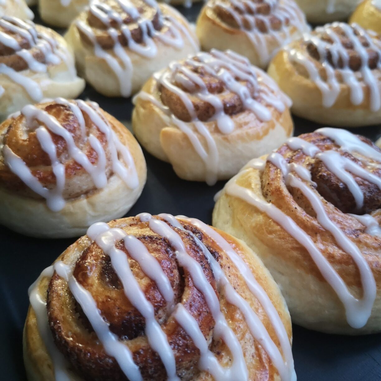 Flera nygräddade bullar på ett fat.