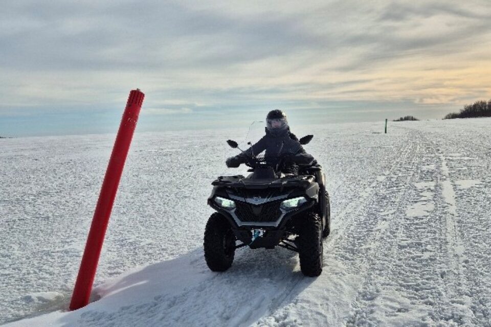 ATV/fyrhjuling på isen en solig vinterdag. Ingen annan i sikte.
