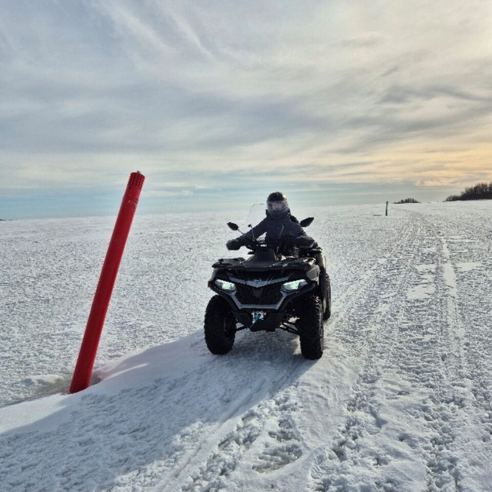 ATV/fyrhjuling på isen en solig vinterdag. Ingen annan i sikte.